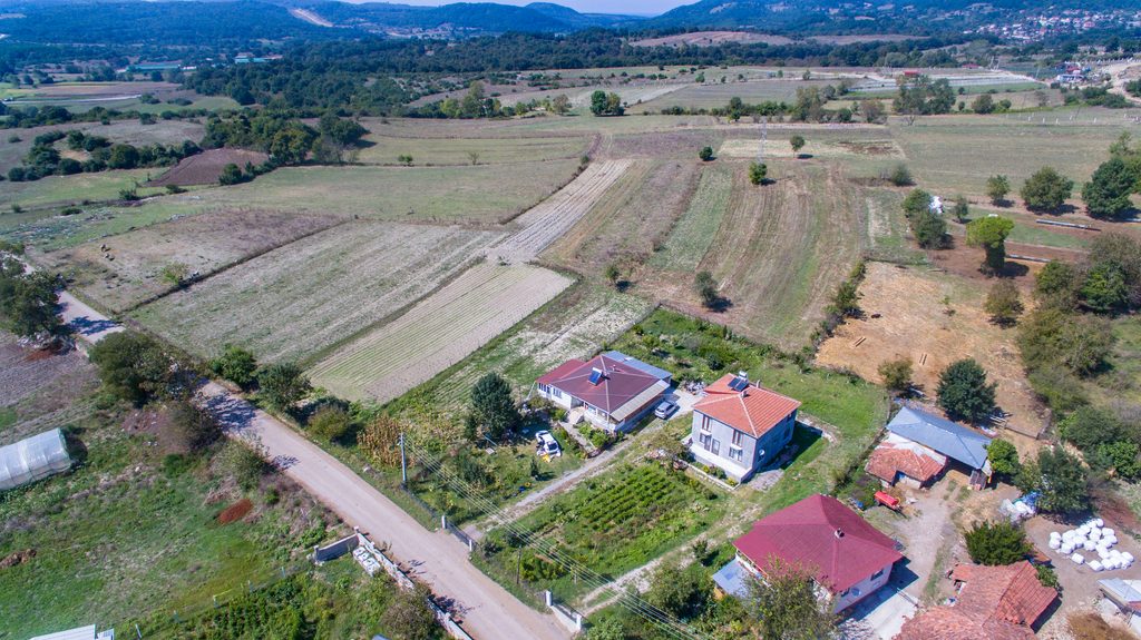 Aerial view of rural homes beside farm fields showing how nearby land use can signal hidden PFAS risk for private wells