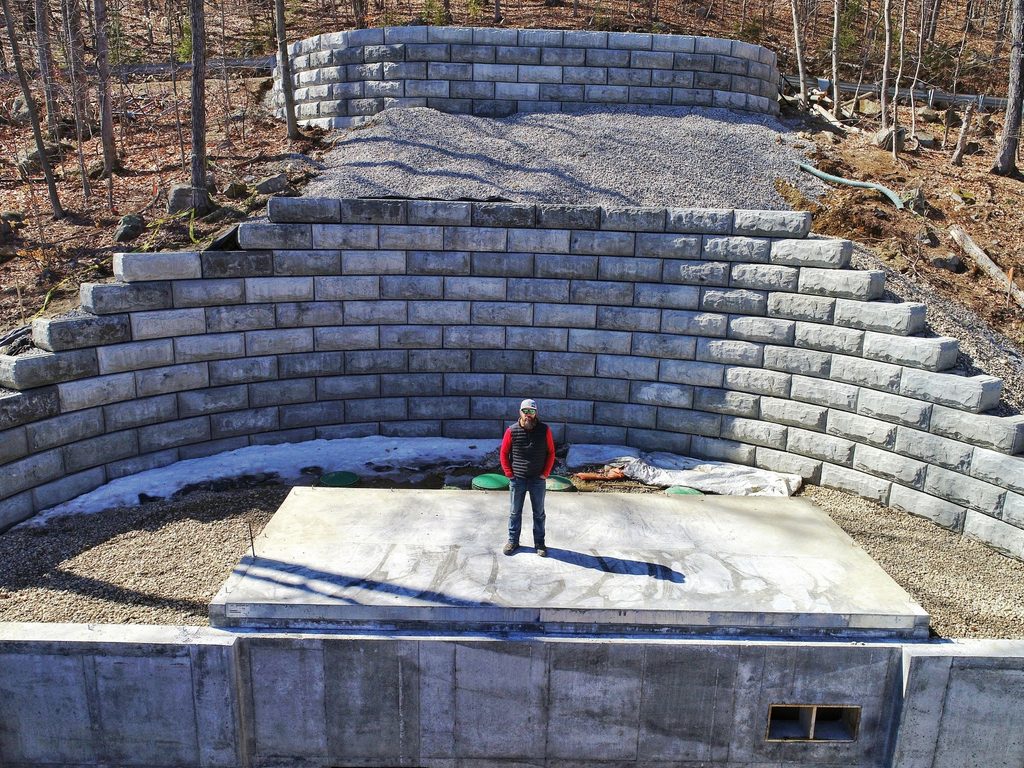 stong strong systems crew member with structural retaining wall blocks in the background